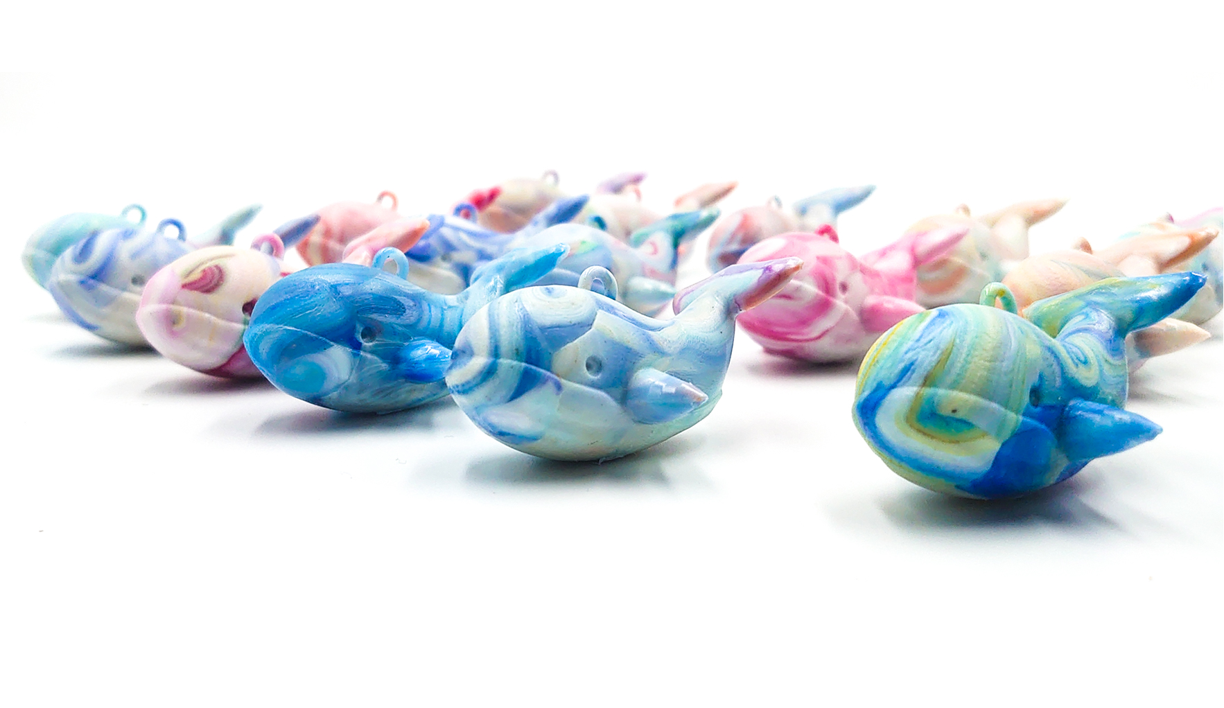 廃ペットボトルキャップから成形されたマーブル模様のクジラキーホルダー。Precious Plastic 唐津のサーキュラーデザイン