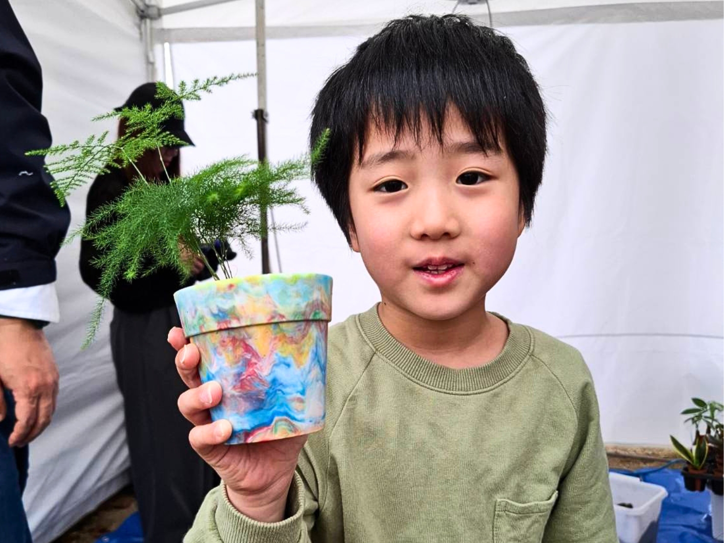 自分でアップサイクルしたフラワーポットに鉢植えする子どもたち