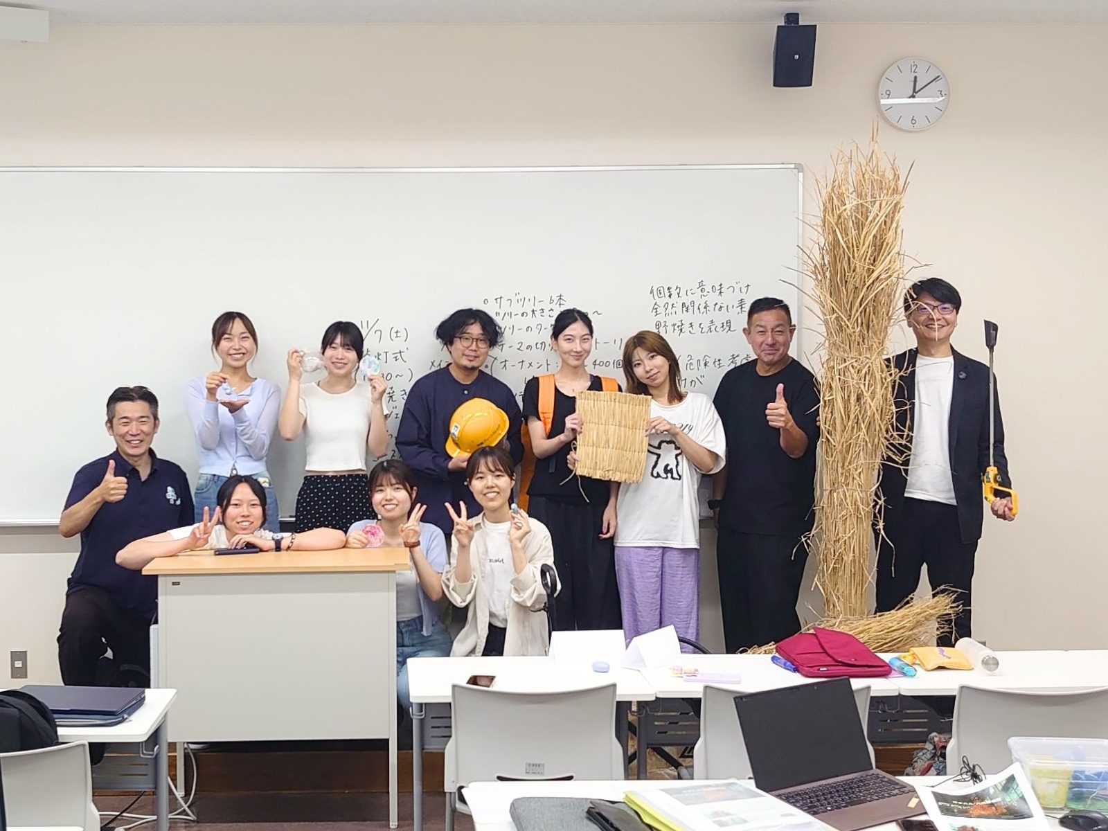 福岡女子大学の教室で、茅の束を囲んで並ぶ学生と大丸福岡天神店・唐津Farm&Foodのメンバーの集合写真
