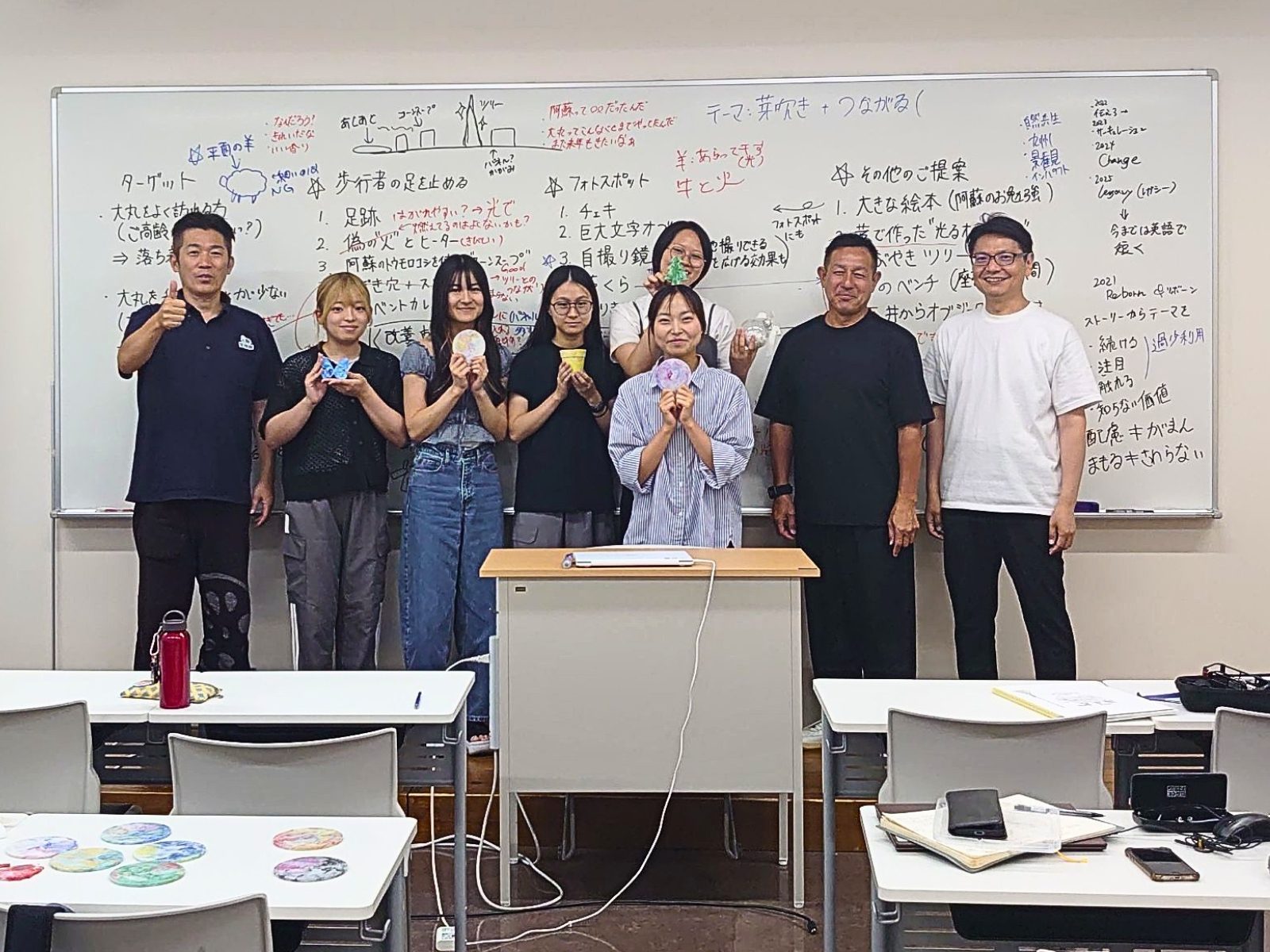 福岡女子大学の教室で、手のひらサイズのオーナメント試作品を持って並ぶ学生たちと大丸福岡天神店・唐津Farm&Foodのメンバーの集合写真