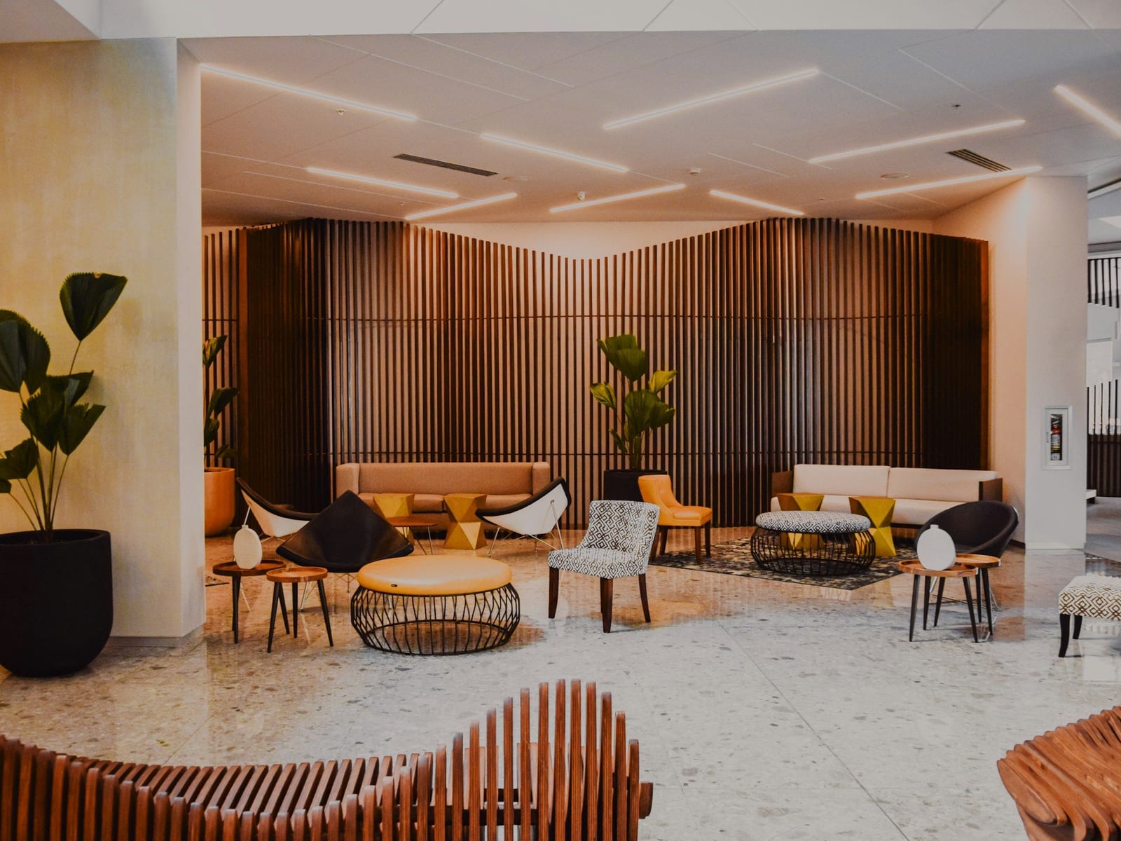 A hotel lobby with wooden walls and sofas