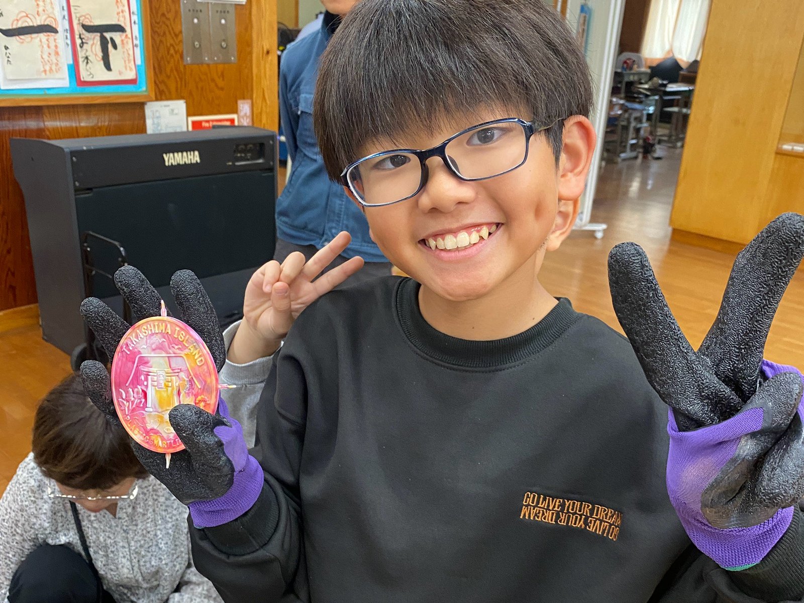 A Takashima Elementary pupil holding a pink marbled coaster