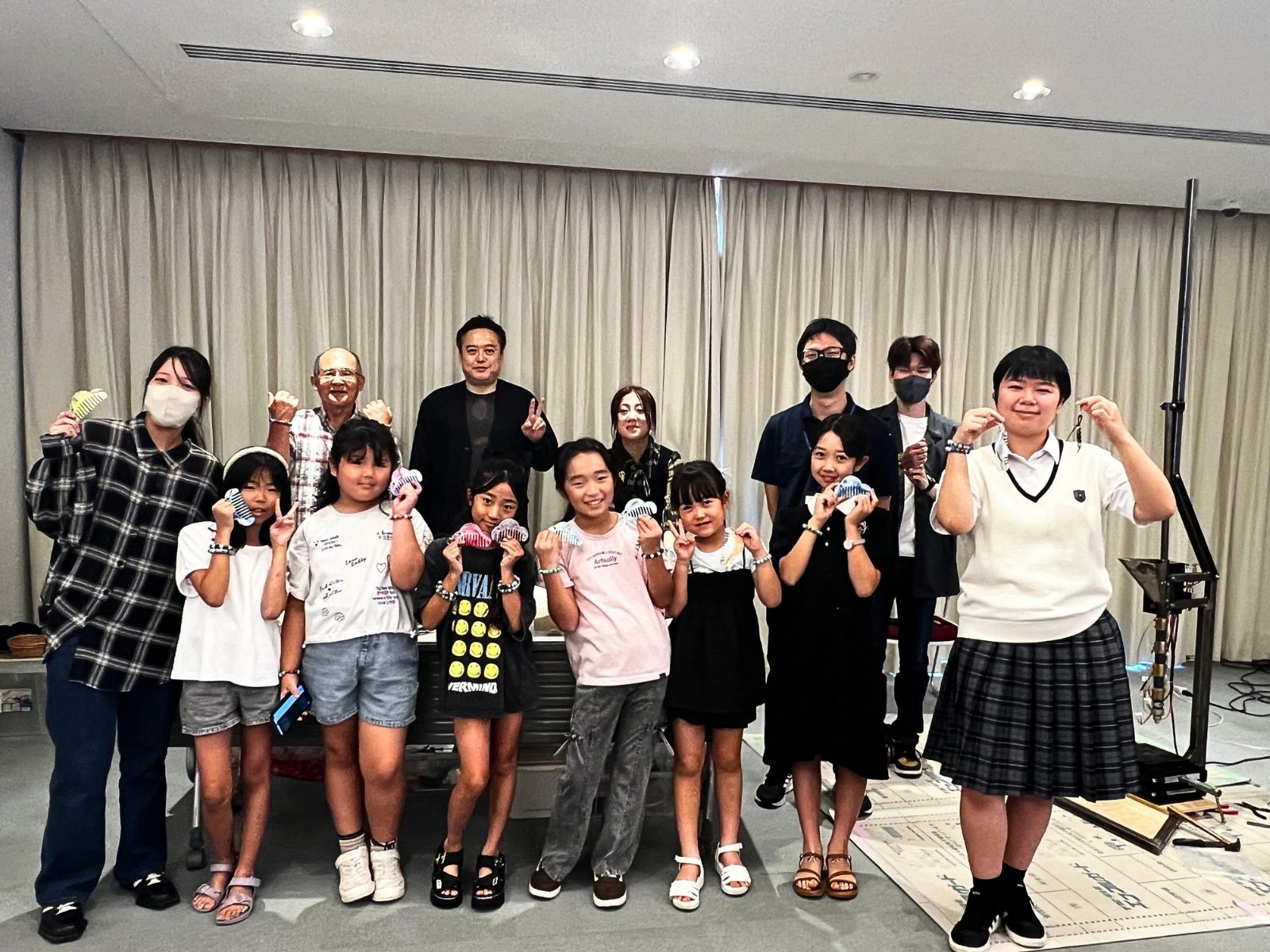 瀬戸内市民図書館の会場で、できあがった作品を手に並ぶ子どもたちとプラ芸の学生、スタッフの集合写真