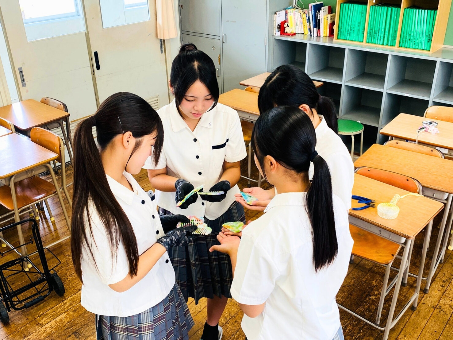 できあがったばかりの櫛を手のひらにのせて見せ合う生徒たち