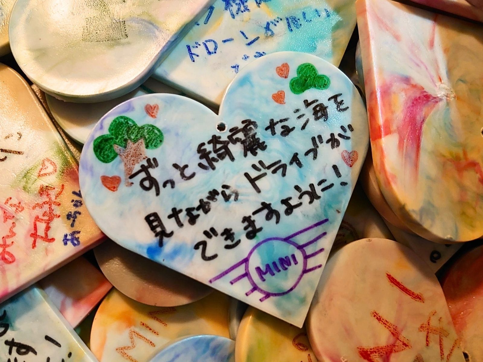 「ずっと綺麗な海を見ながらドライブができますように！」と手書きされた、ハート型のアップサイクル・オーナメント