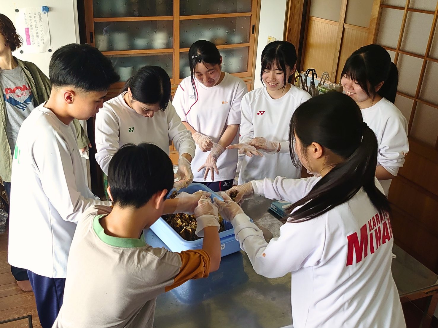 高校生と子どもたちが一緒に巣板をしぼる様子