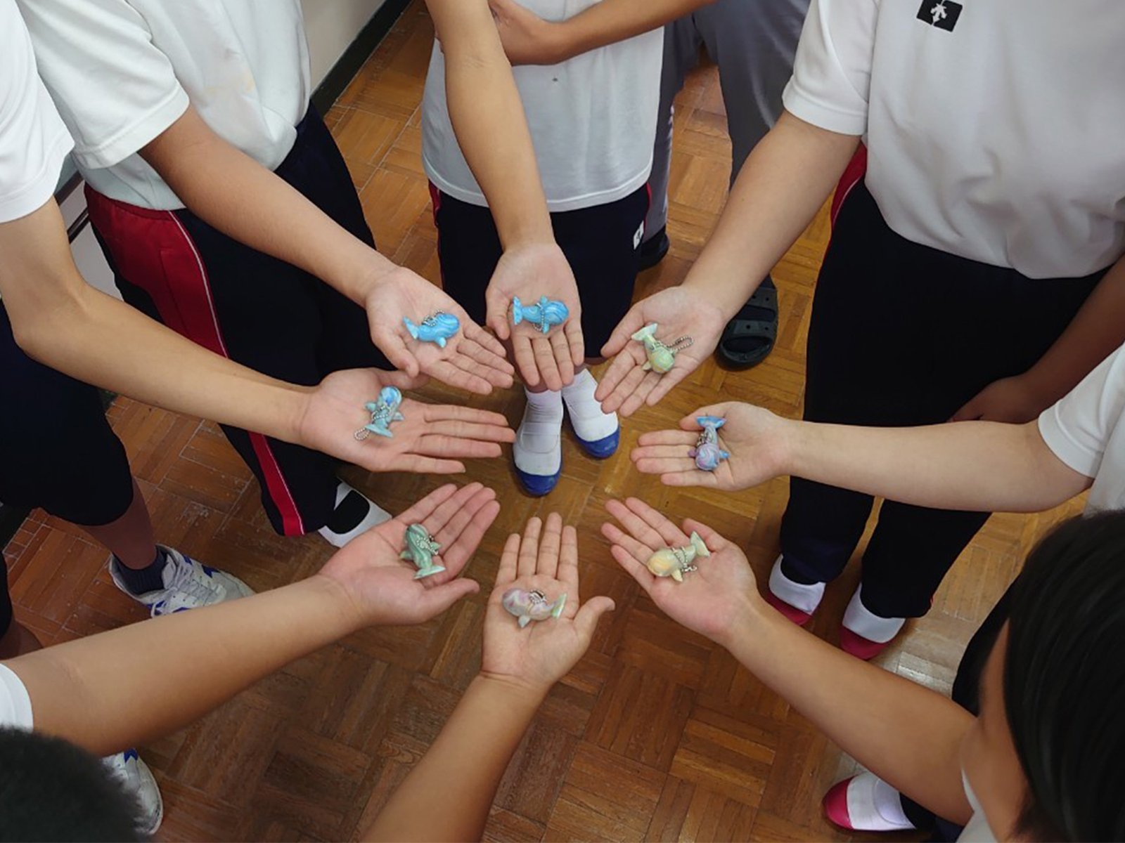 小川島でお披露目したクジラのキーホルダーを手のひらにのせる小川島と加唐島の子どもたち