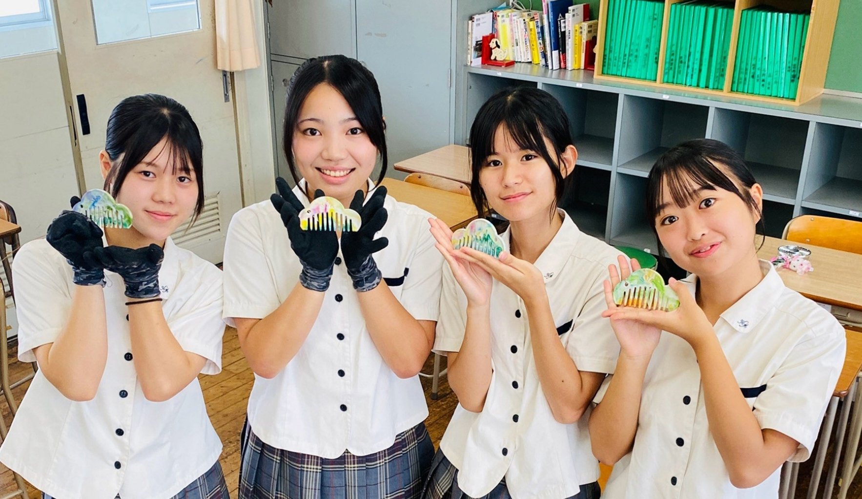 自分たちがデザインした松モチーフの櫛「Re comb」を手に笑顔を見せる、唐津南高校 虹ノ松原プロジェクトチームの生徒4名