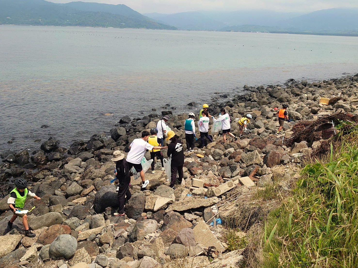 高島の岩場の海岸で海ごみを拾う子どもたち