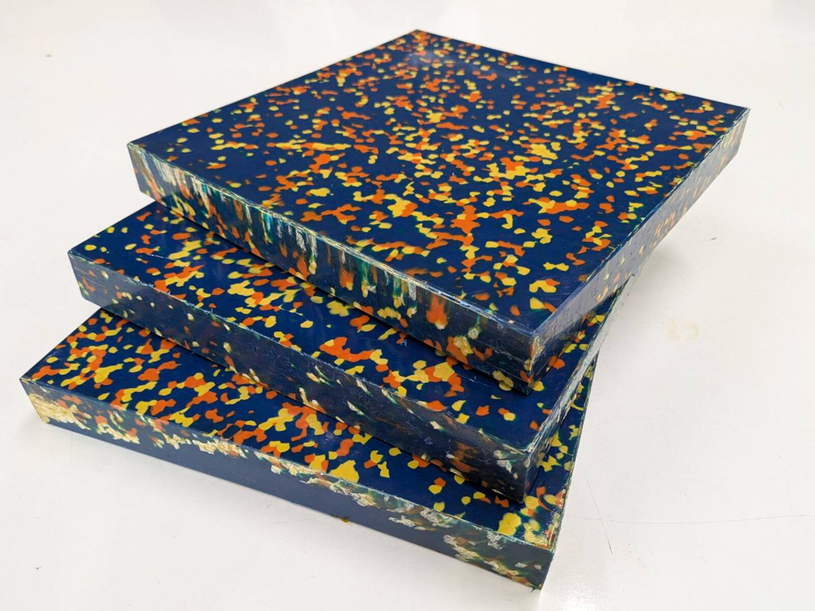 Prototype sheets pressed from 100% ocean-recovered plastic from Tsushima, blue with multicolored flakes