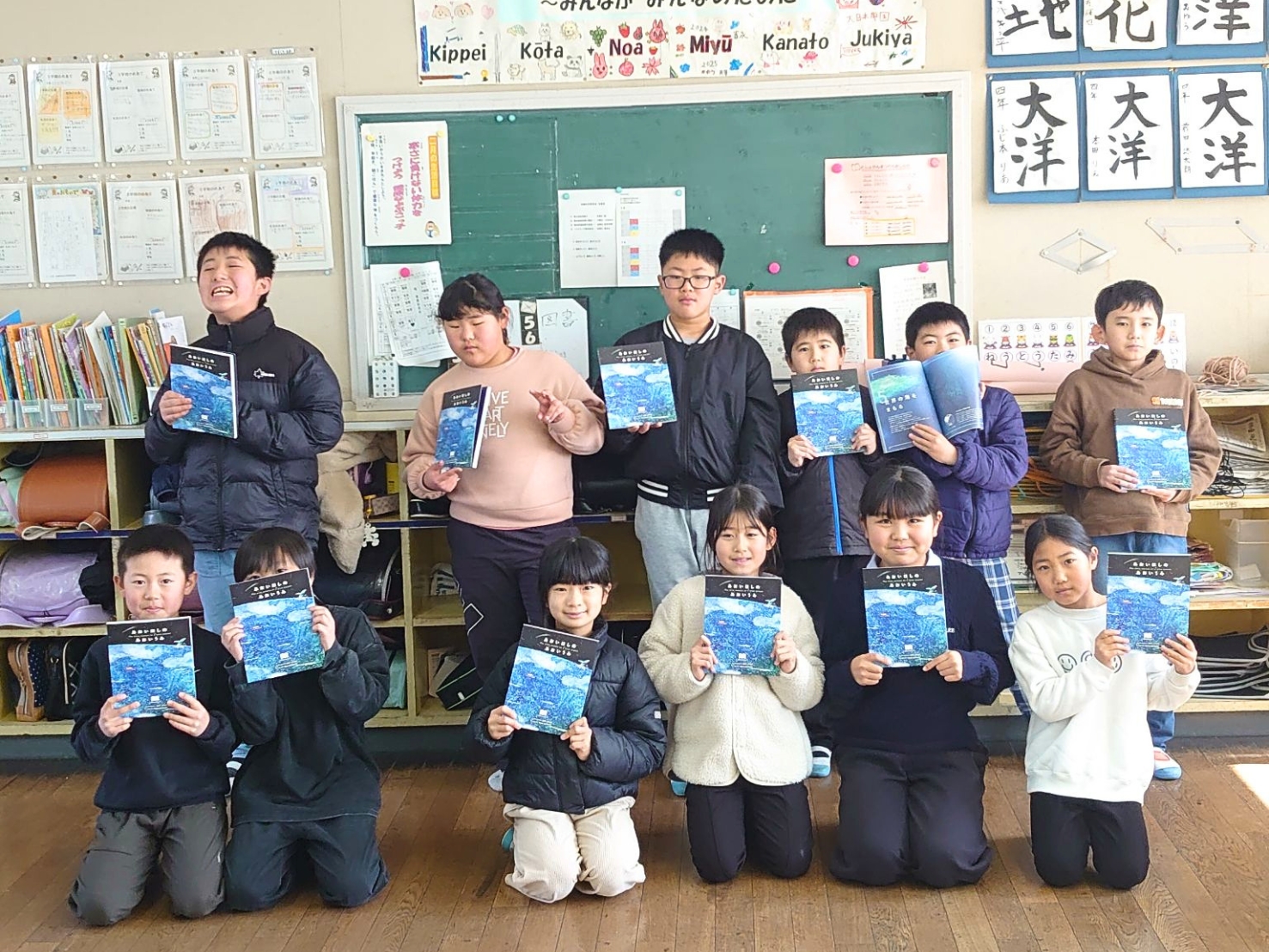 呼子小学校で『あおいほしのあおいうみ』を手にする子どもたち
